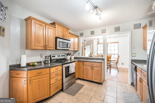 a kitchen with stainless steel appliances granite countertop a refrigerator stove top oven and sink