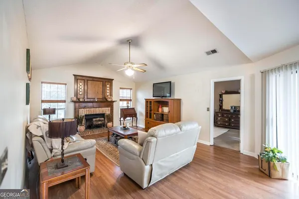 a living room with furniture a fireplace and a flat screen tv