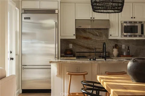 a kitchen with a refrigerator and a stove top oven