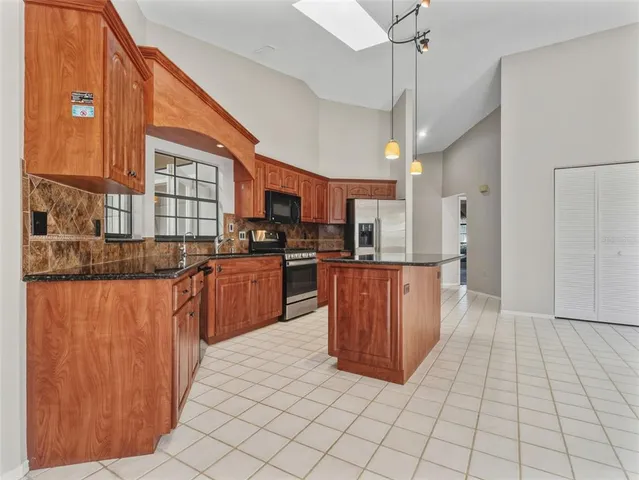 a kitchen with stainless steel appliances granite countertop a stove a sink dishwasher and a refrigerator