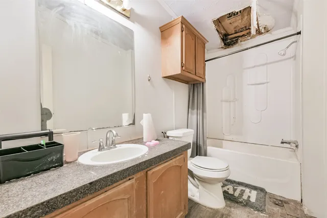a bathroom with a granite countertop sink toilet and shower