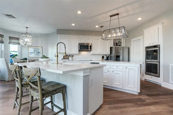a kitchen with kitchen island granite countertop a sink and a refrigerator