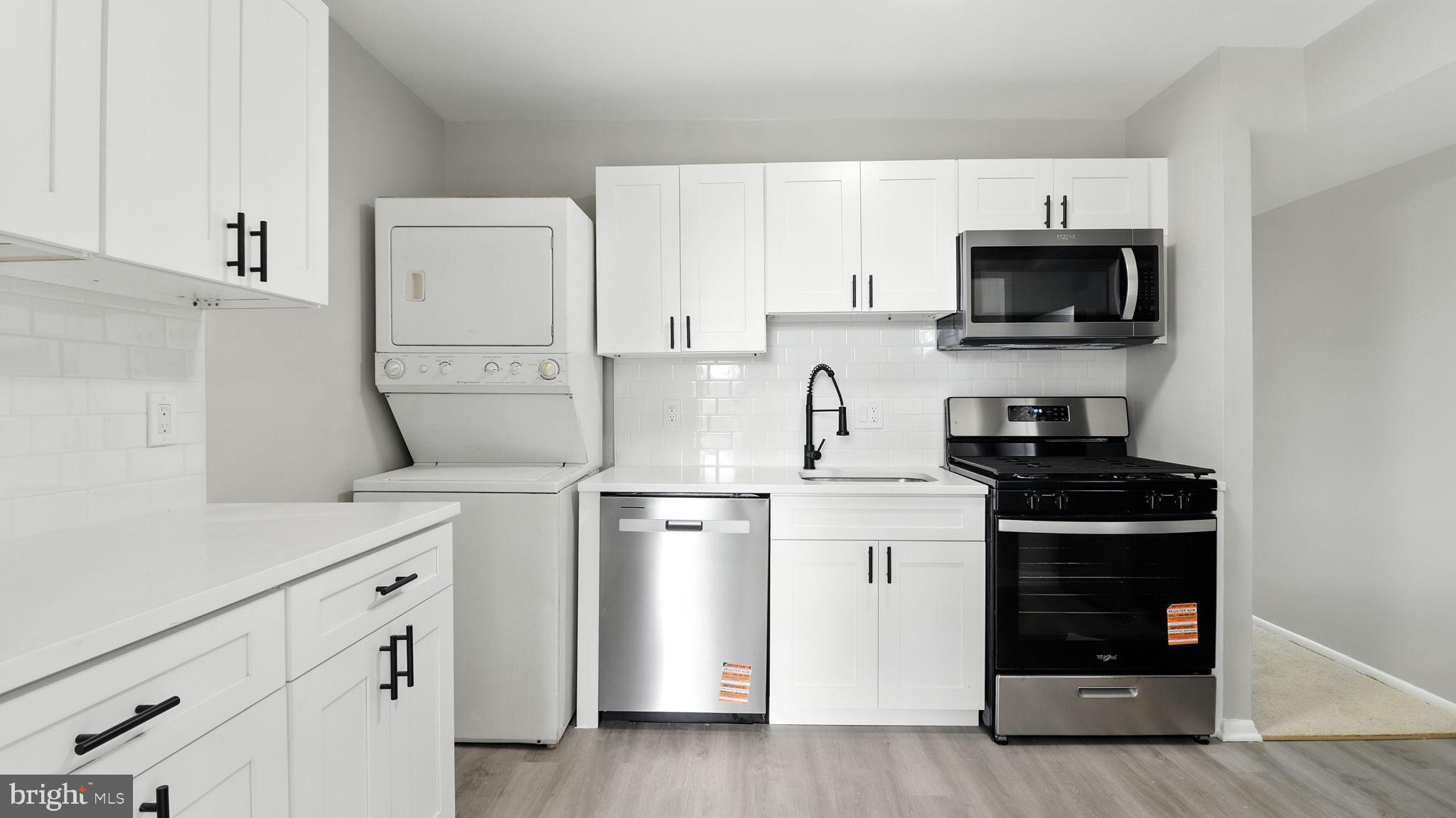 8693 Greenbelt Road, Unit 202 Greenbelt, MD 20770 - Photo 22 of 40 a kitchen with white cabinets and appliances