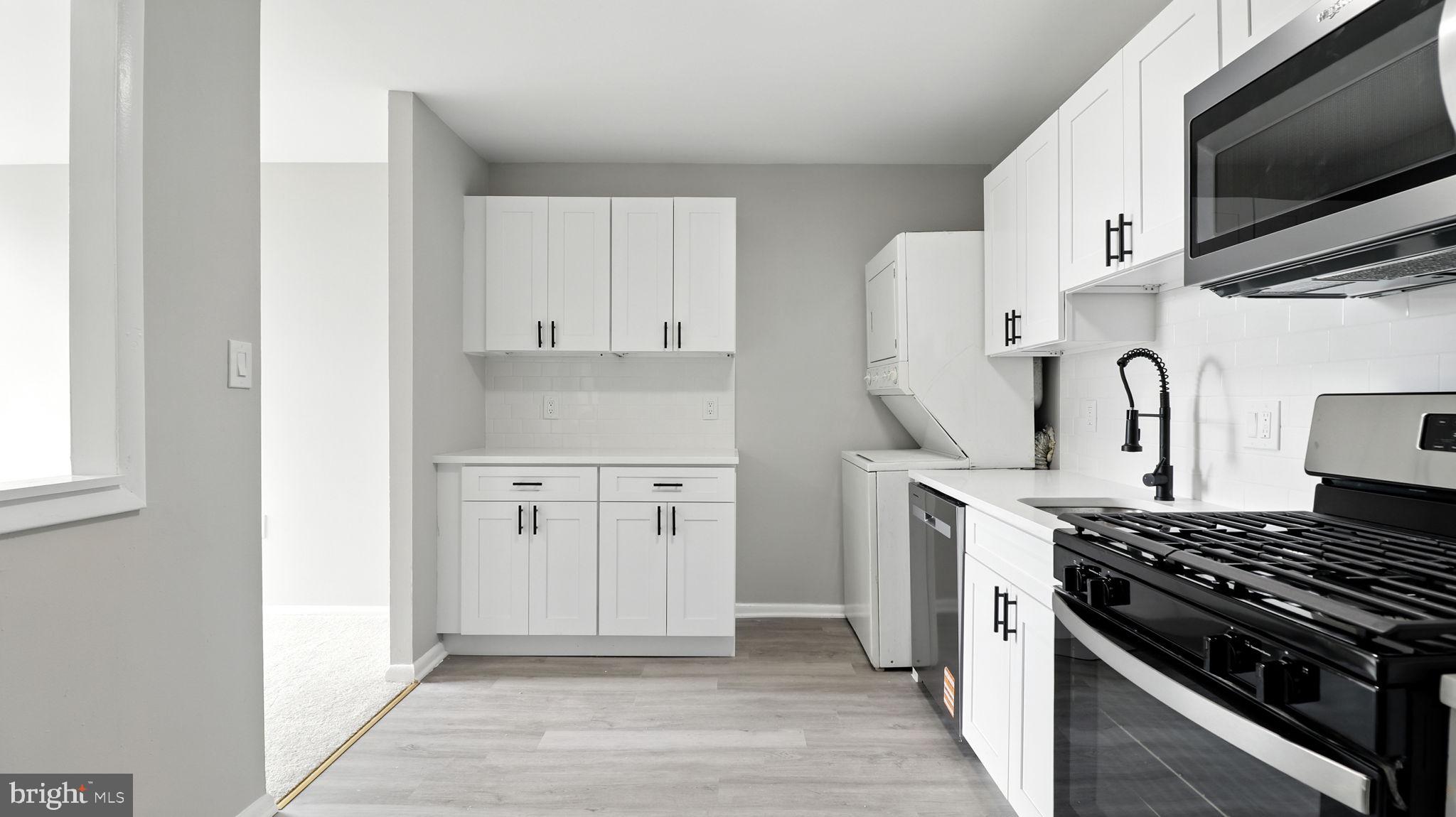 8693 Greenbelt Road, Unit 202 Greenbelt, MD 20770 - Photo 25 of 40 a kitchen with white cabinets and appliances