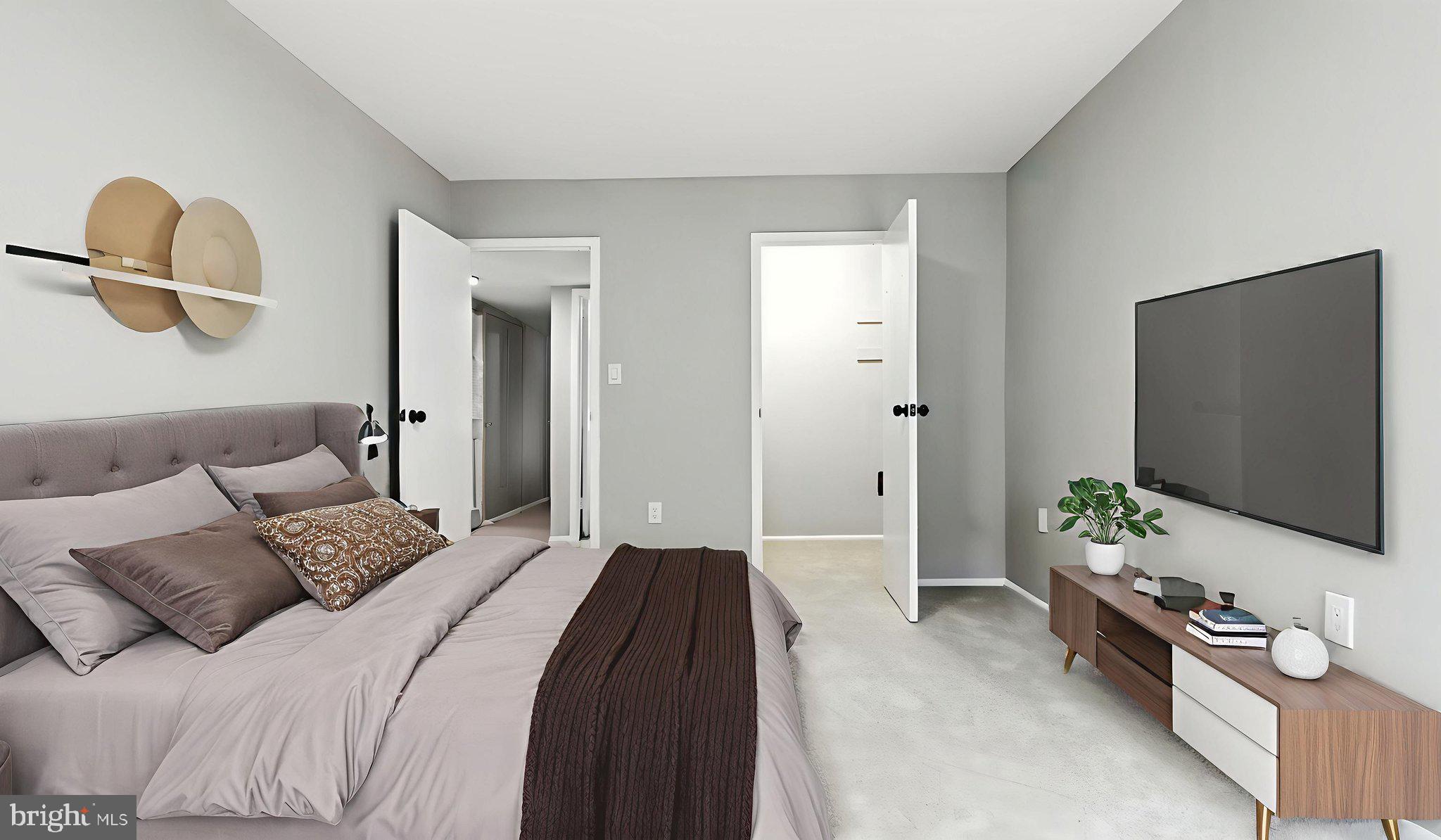 8693 Greenbelt Road, Unit 202 Greenbelt, MD 20770 - Photo 33 of 40 a bedroom with a bed and a flat screen tv