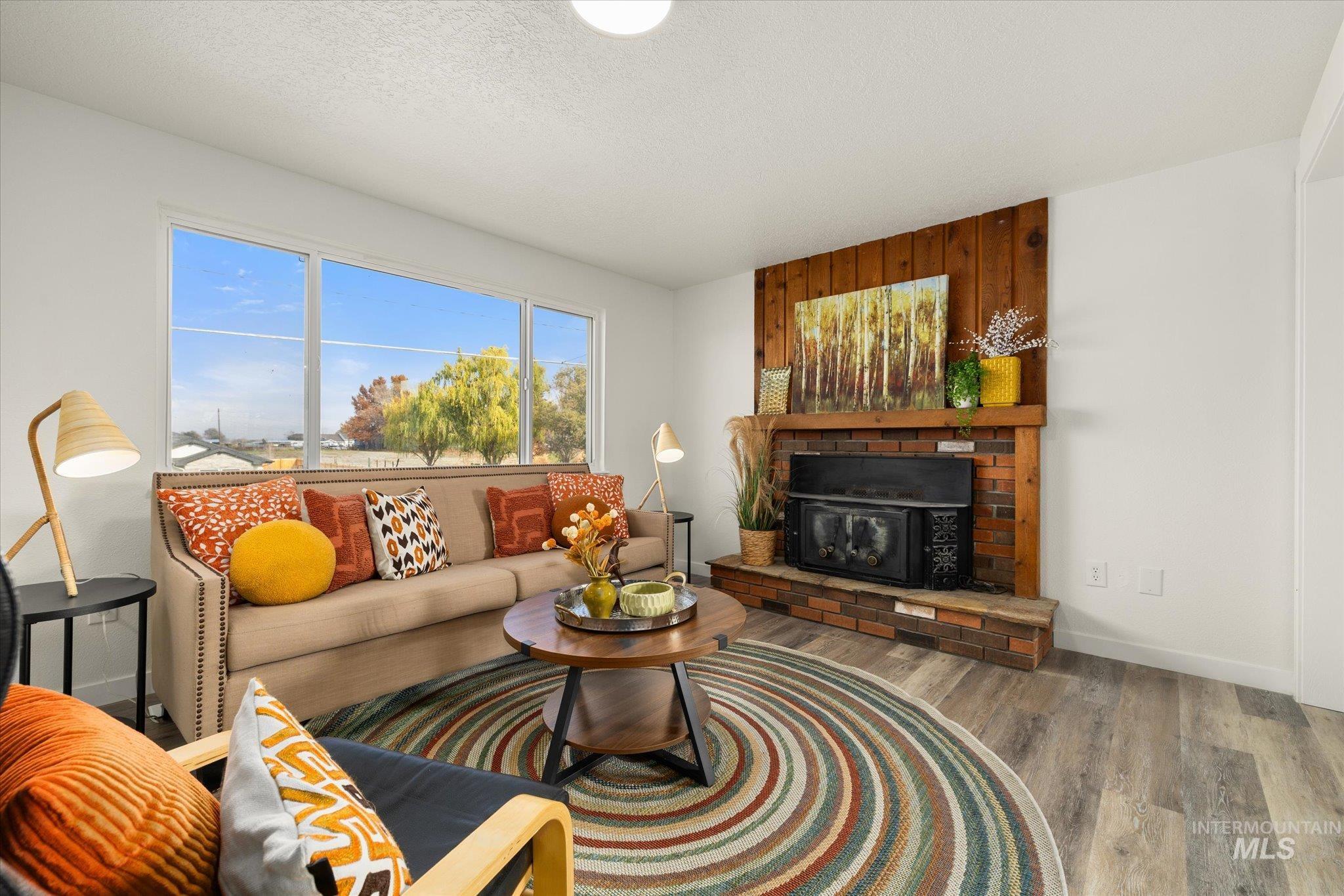 419 West Logan Street Caldwell, ID 83605 - Photo 8 of 50 Living room with a fireplace, wood finished floors, and a textured ceiling