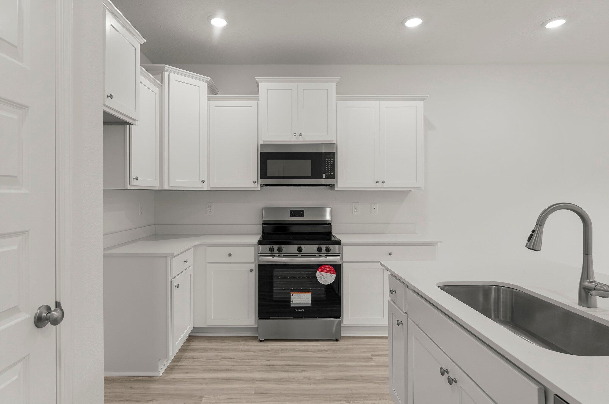 44 Hawk Street Santa Rosa Beach, FL 32459 - Photo 13 of 34 a kitchen with white cabinets appliances and a sink