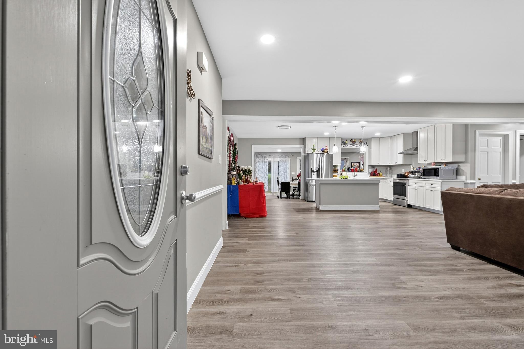 a living room with stainless steel appliances granite countertop furniture and a kitchen view