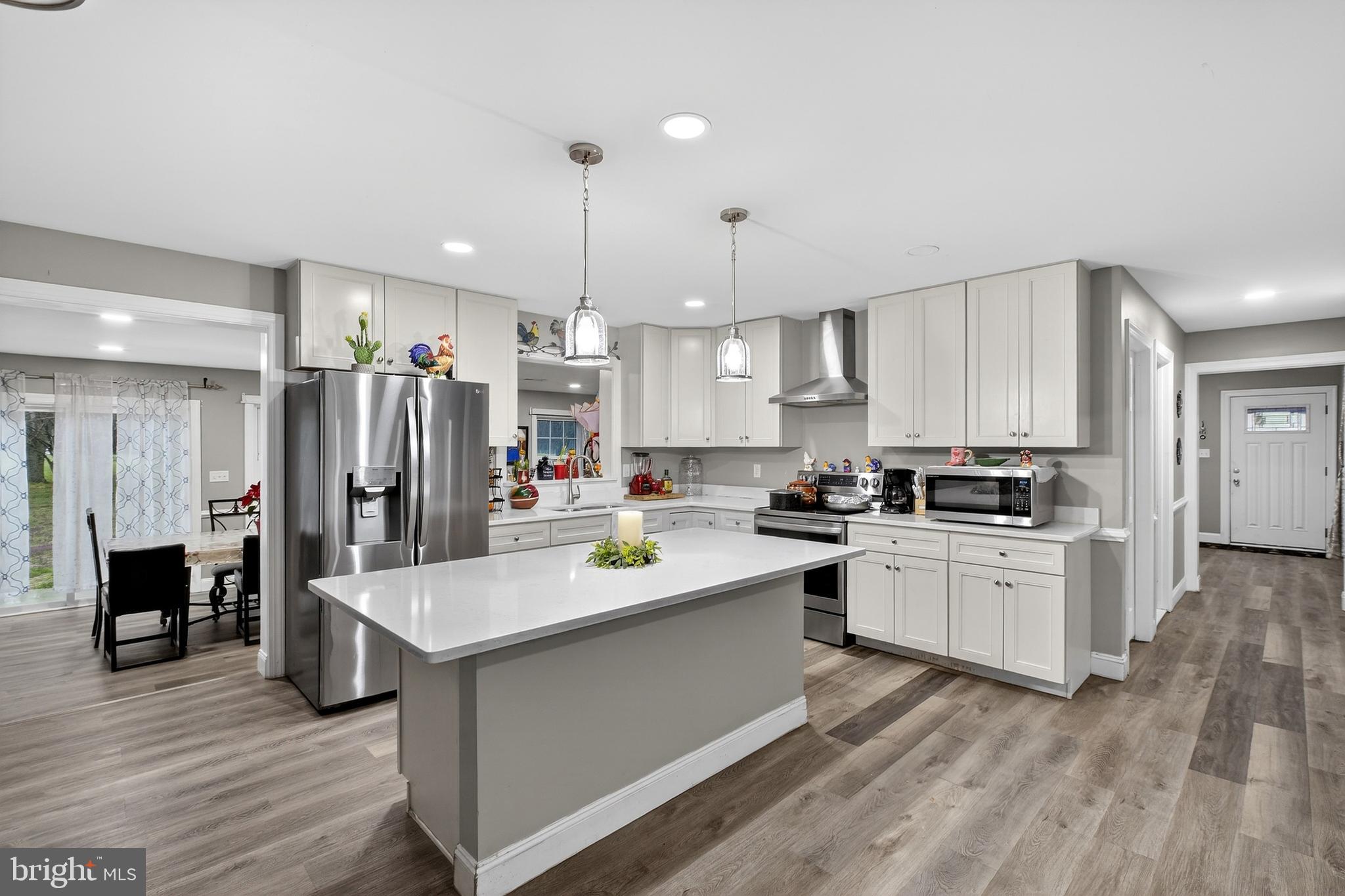 a kitchen with a sink stainless steel appliances and white cabinets