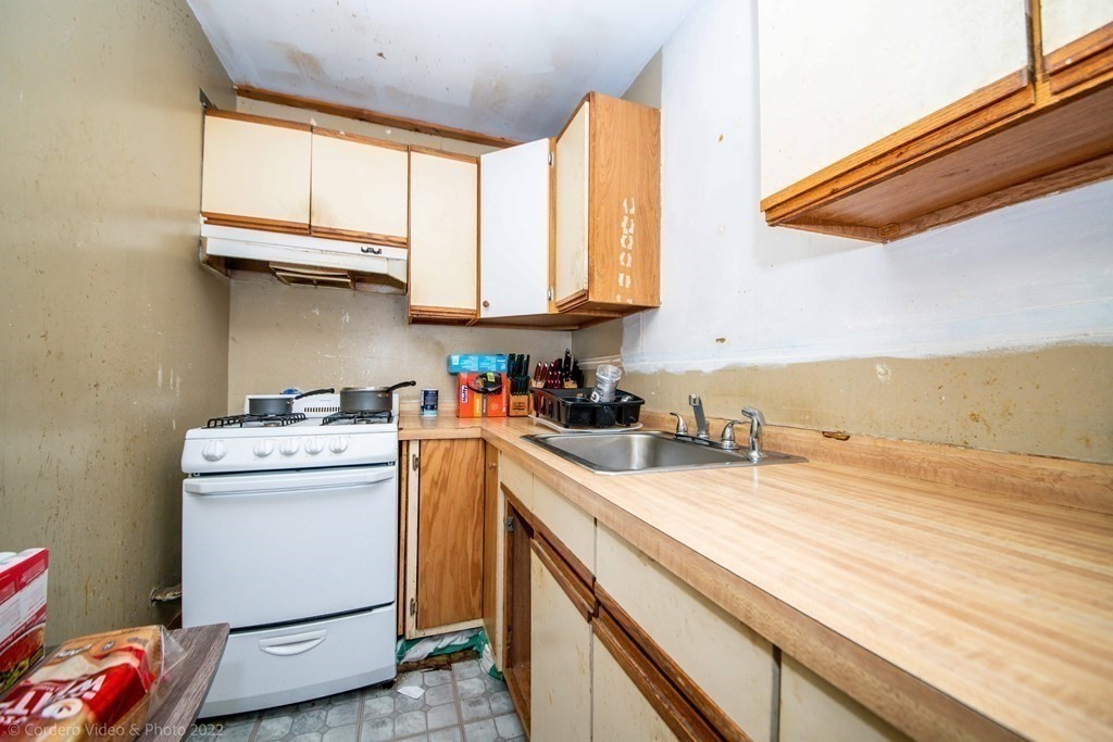 119 Lapham Street Fall River, MA 02721 - Photo 12 of 29 a kitchen with a stove a sink and a microwave