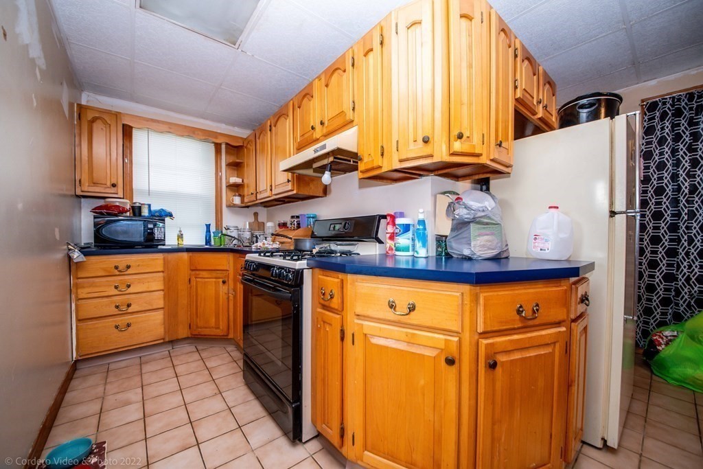 119 Lapham Street Fall River, MA 02721 - Photo 4 of 29 a kitchen with stainless steel appliances a stove a sink and a refrigerator
