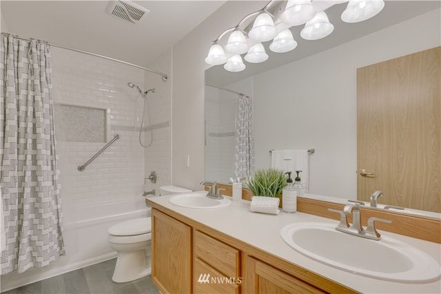 a bathroom with a granite countertop sink a toilet and a mirror