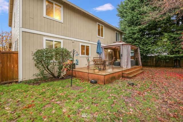 a view of a house with backyard and sitting area