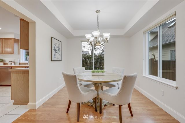 a dining room with furniture a potted plant and a chandelier