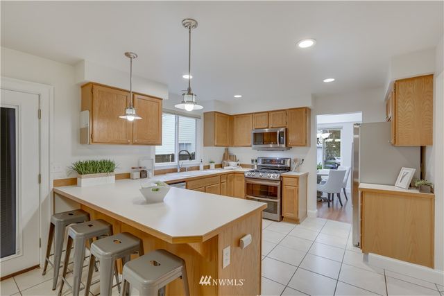 a kitchen with a sink a stove a refrigerator and a center island