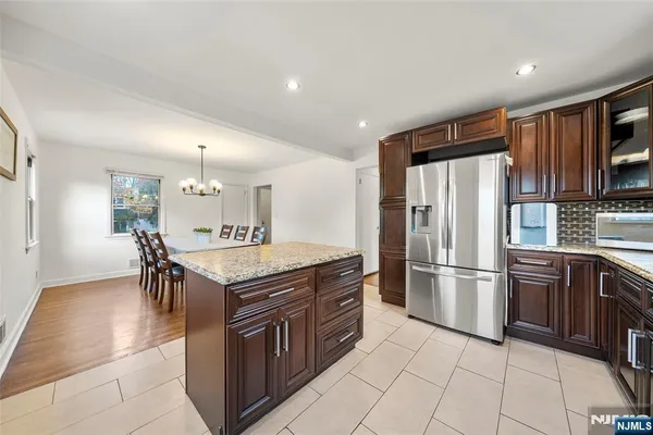 a kitchen with stainless steel appliances granite countertop a stove a refrigerator a sink and a refrigerator