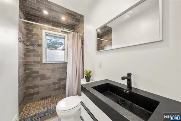 a bathroom with a toilet a sink and mirror