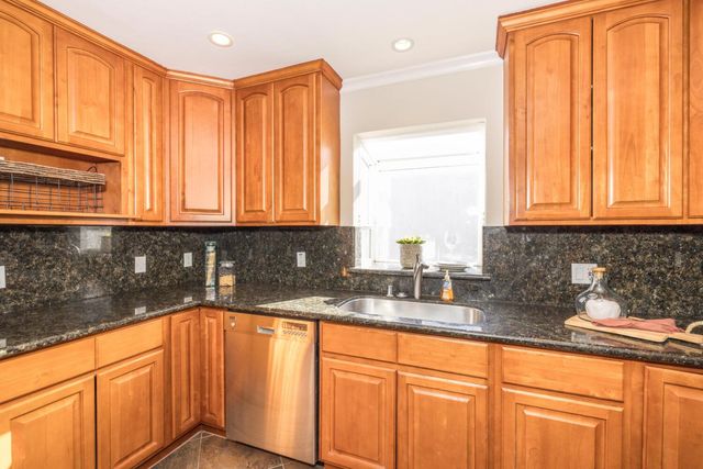 a kitchen with stainless steel appliances granite countertop a sink a refrigerator and cabinets
