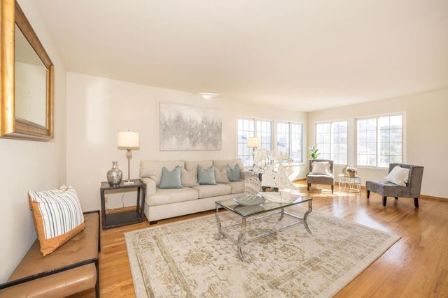 a living room with furniture wooden floor and a table