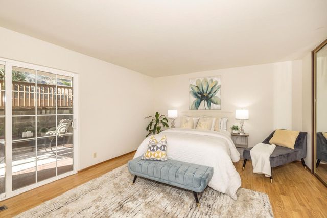 a bedroom with a bed and a large window