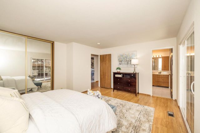 a bedroom with a bed and a large mirror on the dresser