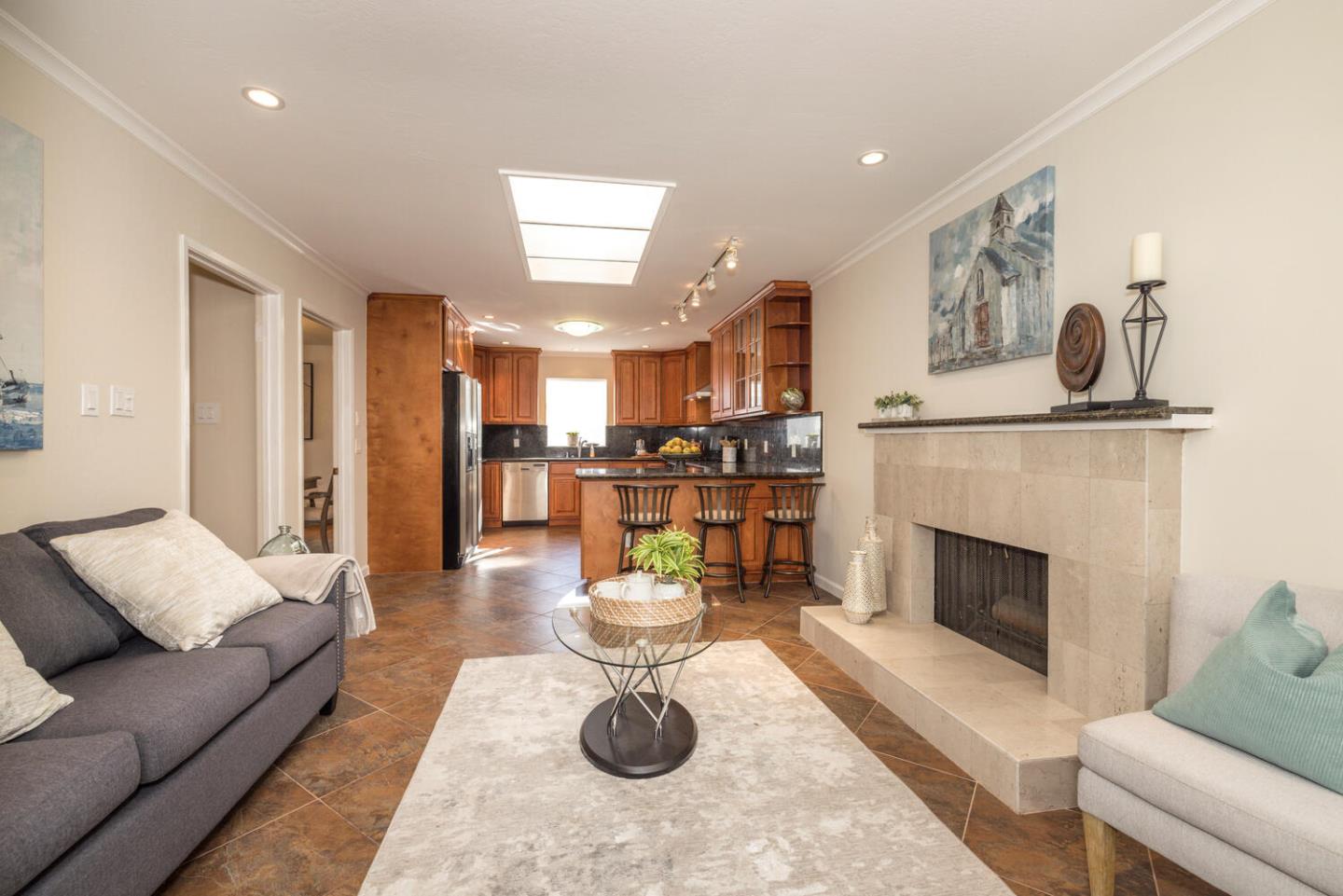 873 Morningside Drive Millbrae, CA 94030 - Photo 7 of 47 a living room with furniture a fireplace and kitchen view