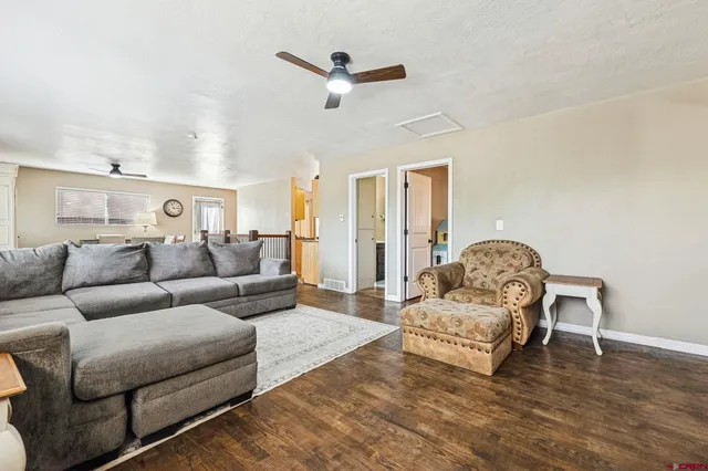 a living room with furniture and a ceiling fan