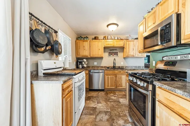 a kitchen with stainless steel appliances granite countertop a stove a sink and a microwave