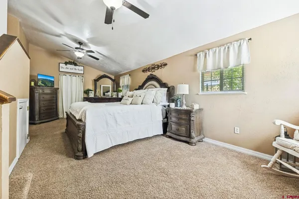 a bedroom with a bed next to a window and a chandelier