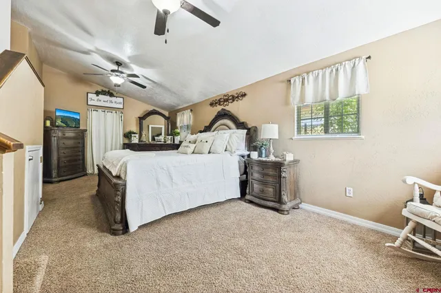a bedroom with a bed next to a window and a chandelier