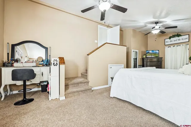 a bedroom with a bed a chandelier and a potted plant on the wall