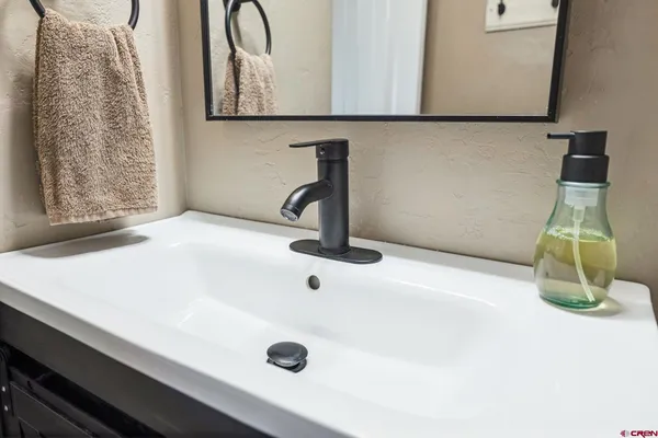 a bathroom with a sink a toilet and a mirror