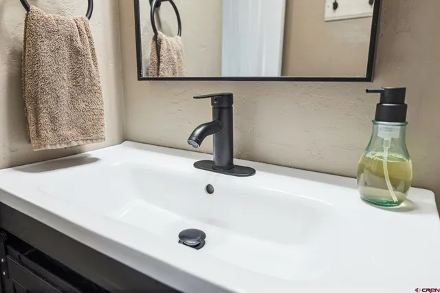 a bathroom with a sink a toilet and a mirror