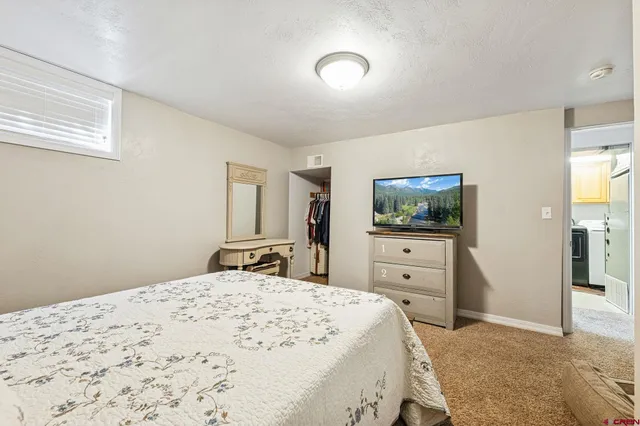 a bedroom with a bed and a flat tv screen on the dresser