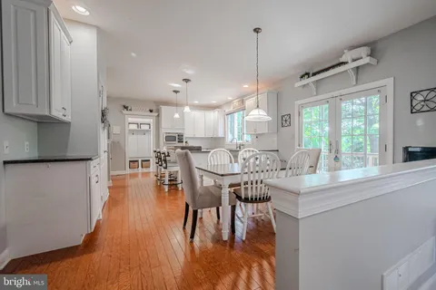 a view of a dining room and livingroom with furniture wooden floor a chandelier