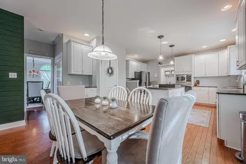 a view of a dining room and livingroom with furniture wooden floor a chandelier
