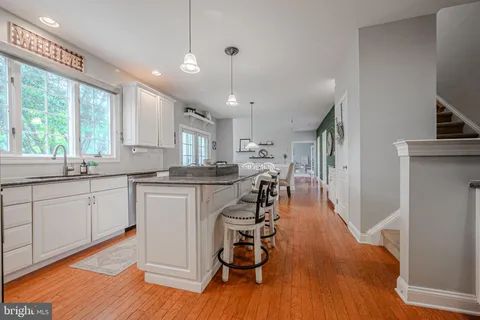 a kitchen with stainless steel appliances granite countertop wooden floors sink and cabinets