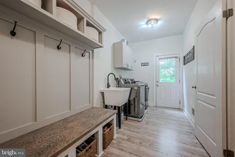 a view of a hallway with furniture and wooden floor
