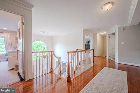 a view of a hallway with wooden floor and door