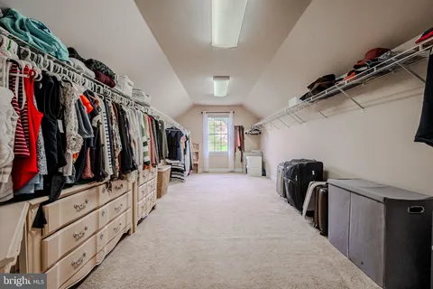 walk in closet with clothes and shoes