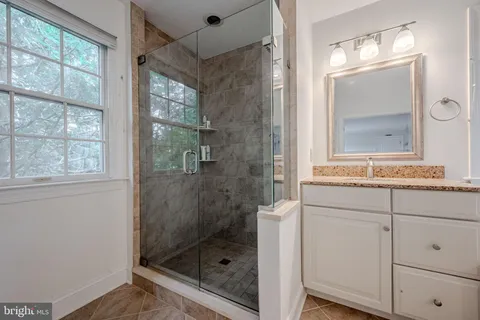 a bathroom with a shower sink and mirror