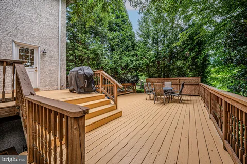 a balcony with wooden floor table and chairs