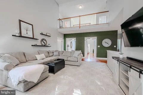 a living room with furniture a flat screen tv and kitchen view