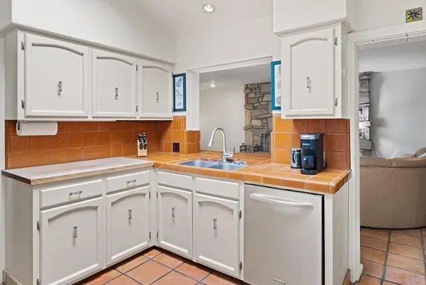 a kitchen with white cabinets and white appliances