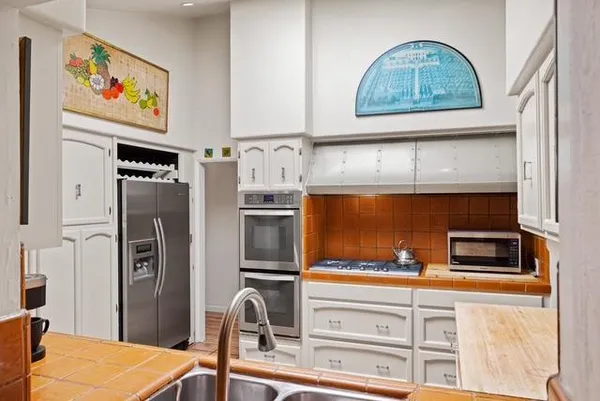 a kitchen with stainless steel appliances granite countertop a refrigerator and a stove