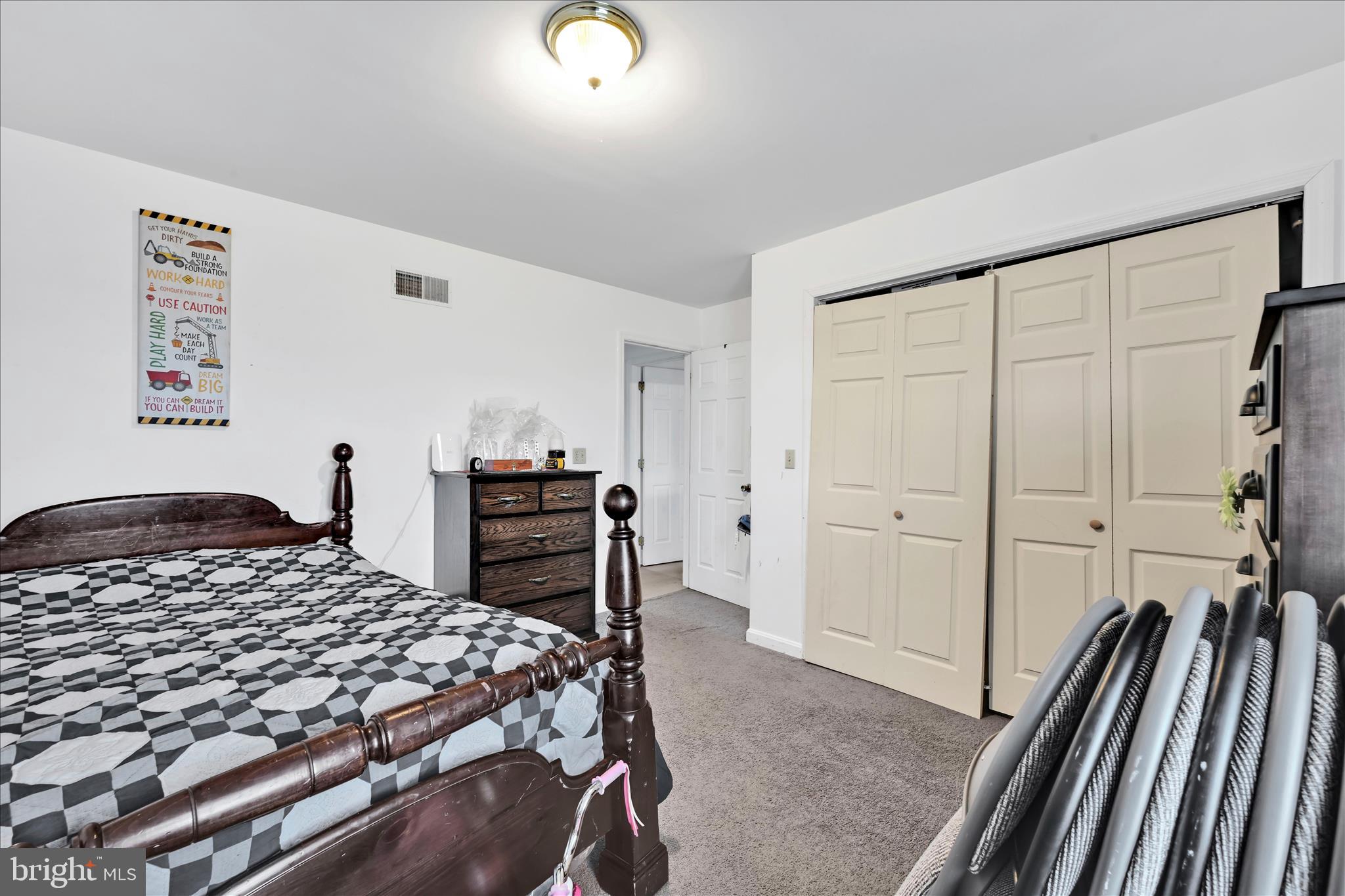 411 Red Hill Road Pequea, PA 17565 - Photo 21 of 50 a bedroom with a bed and a walk in closet with wooden floor