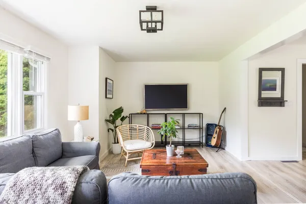 a living room with furniture a flat screen tv and a large window