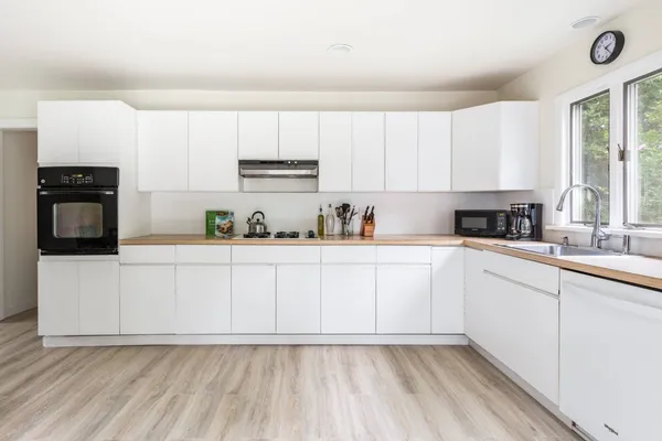 a kitchen with cabinets stainless steel appliances a sink and a window