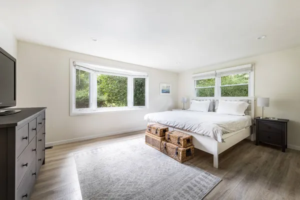 a large bed sitting in a bedroom next to a window