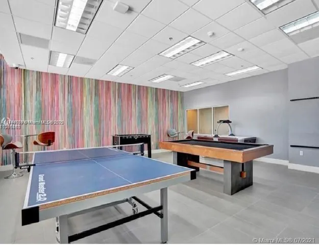 a living room with furniture a table and large windows